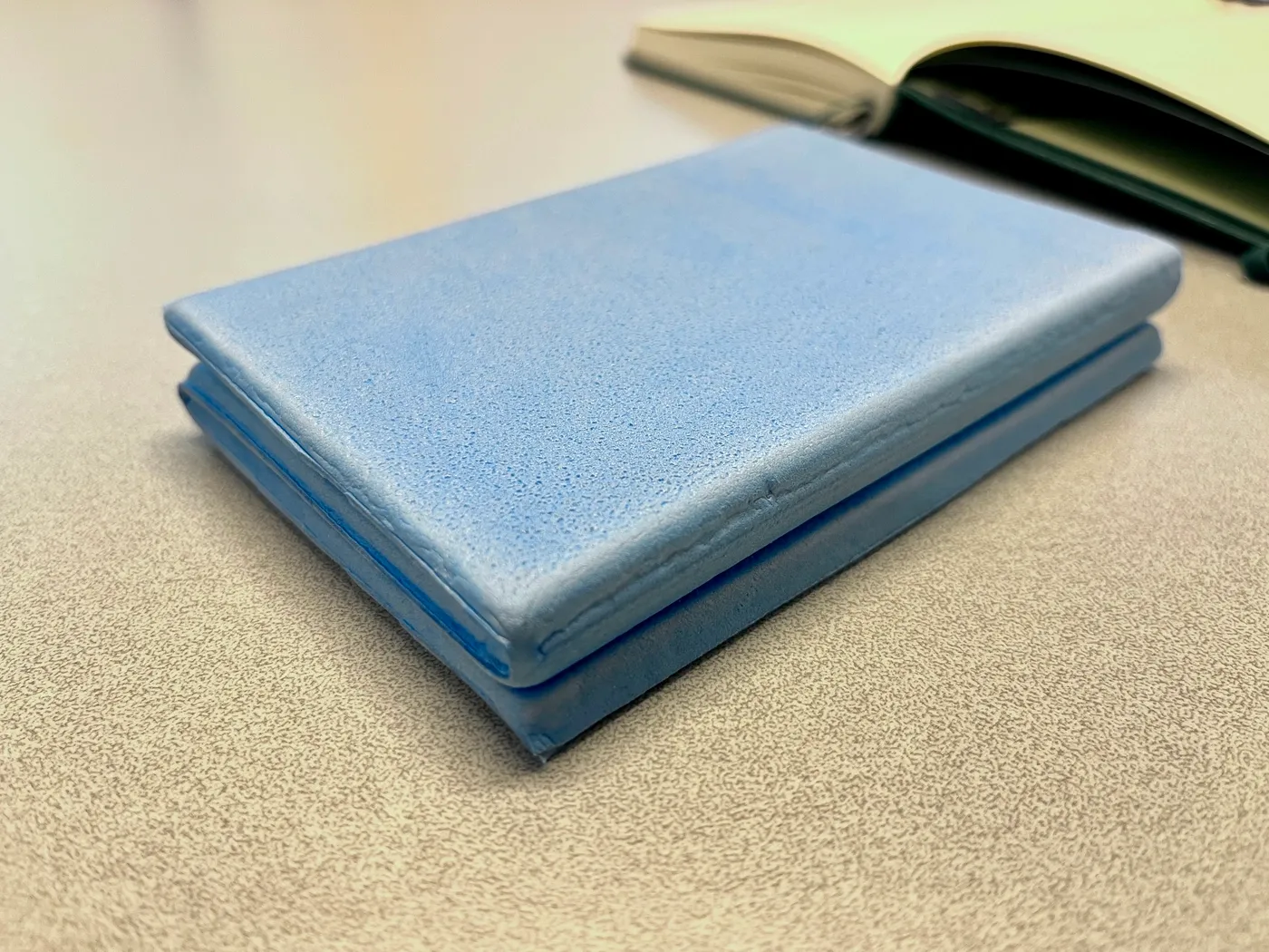 A picture of the cut seat pad to work as the writing cushion. In the back an A5 notebook.