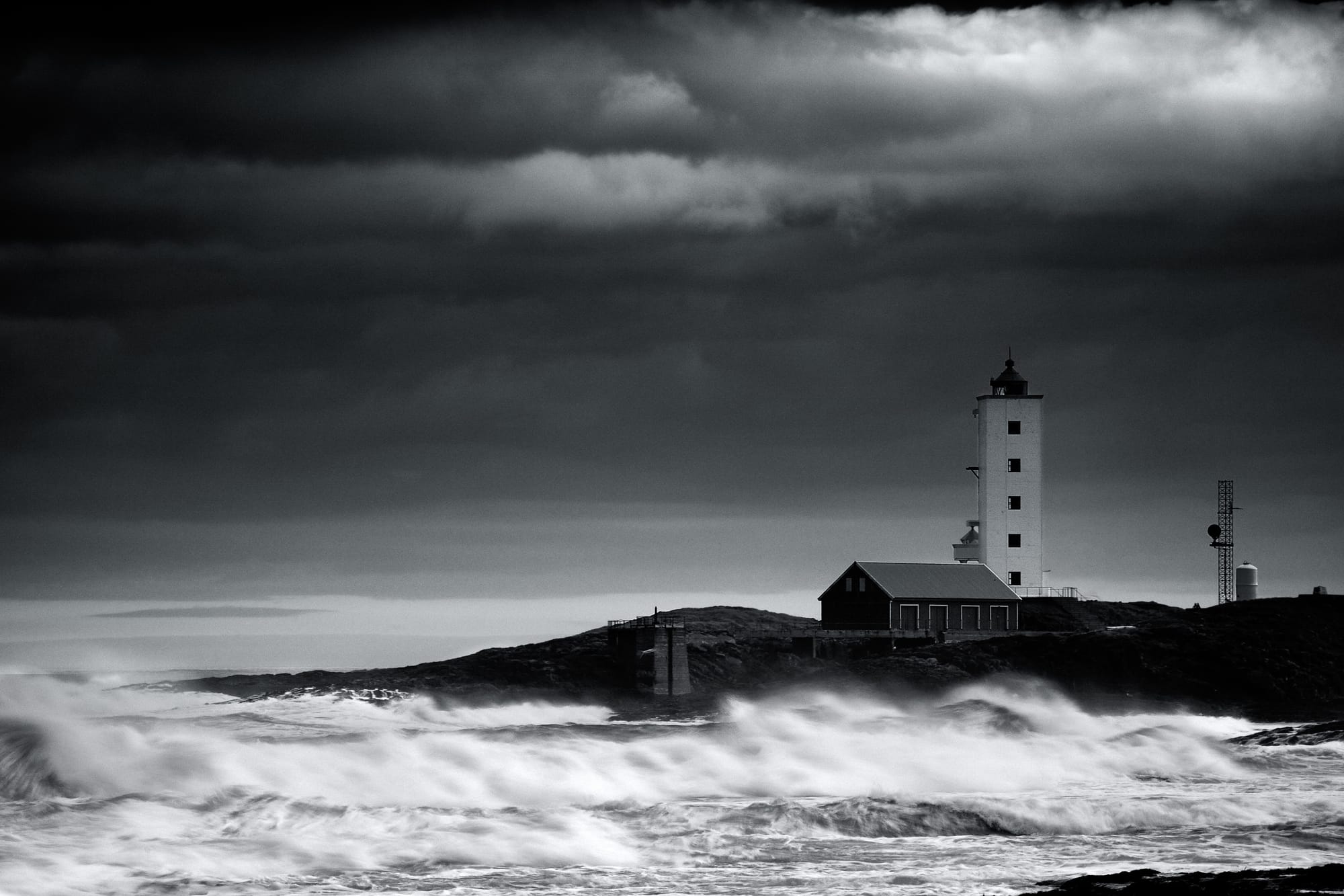 Berlevag Lighthouse A black and white image of the Berlevag lighthouse with waves crashing on the beach